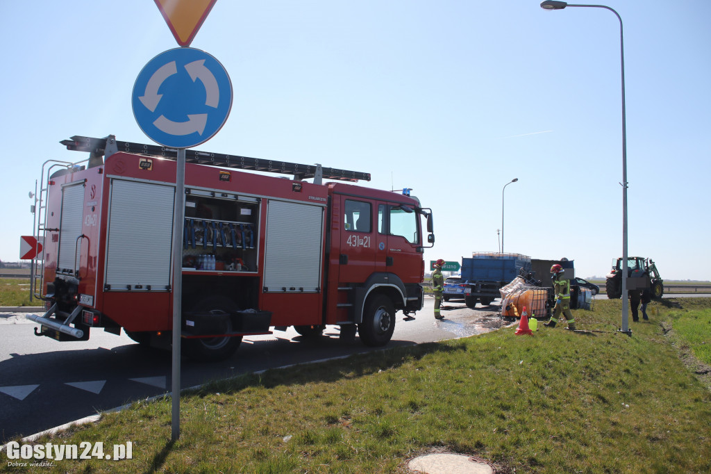 Przewrócona przyczepa i zbiorniki z melasą na rondzie