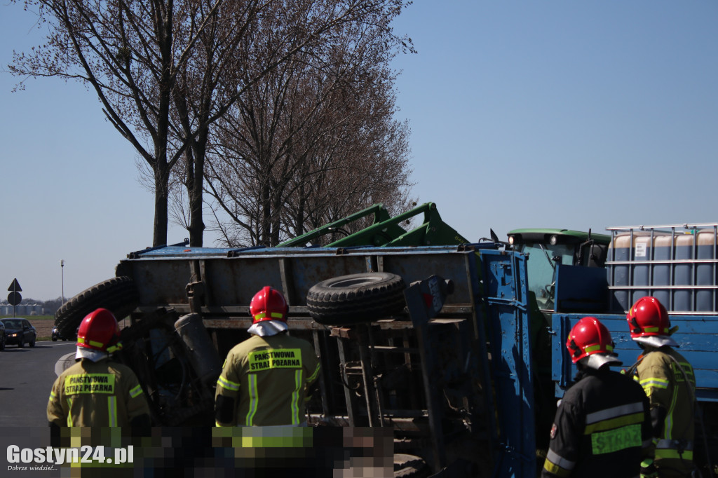 Przewrócona przyczepa i zbiorniki z melasą na rondzie
