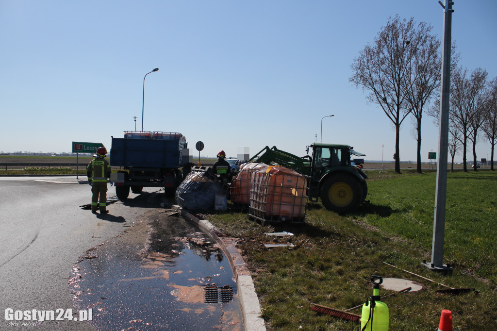 Przewrócona przyczepa i zbiorniki z melasą na rondzie