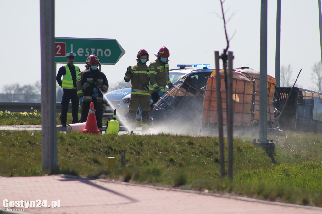 Przewrócona przyczepa i zbiorniki z melasą na rondzie