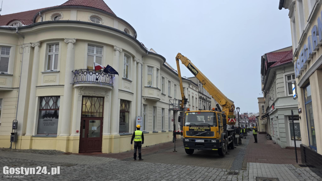 Usuwanie śniegu z dachu miejskiej kamienicy w Gostyniu