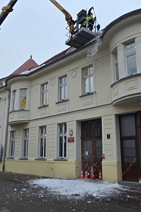 Usuwanie śniegu z dachu miejskiej kamienicy w Gostyniu-13631